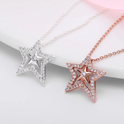 Shimmering Star Pendant Necklace with Crystals - Close-up of two star pendant necklaces, one in sterling silver and the other in rose gold, both adorned with cubic zirconia accents.