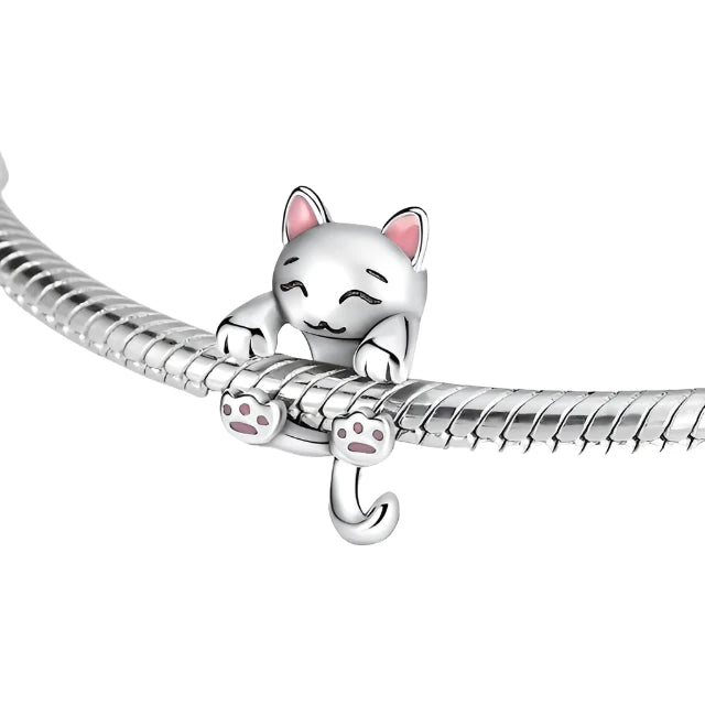 Sterling silver charm of a cat playfully hanging from a bracelet, featuring pink paws and a cute expression, fits with Pandora charms.