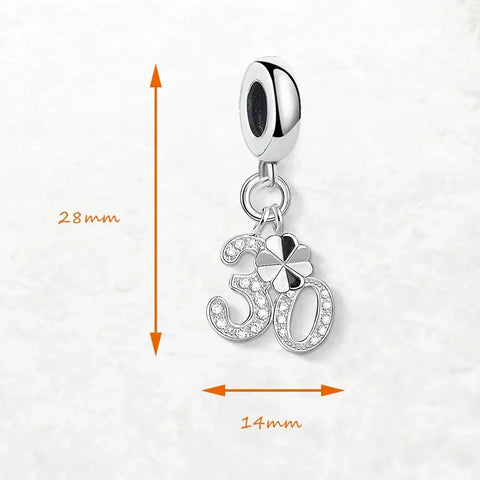 Silver charm with ''' and clover design.
