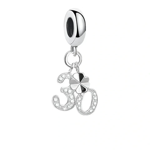 Silver charm with number  and clover.