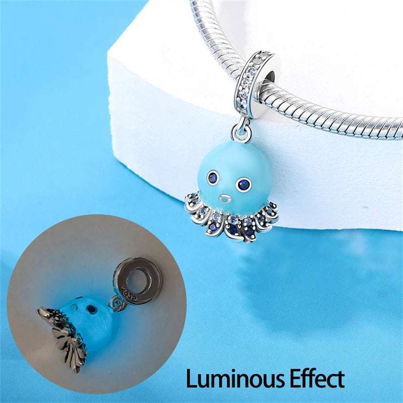 Detailed octopus charm in aqua with blue crystals and sterling silver.