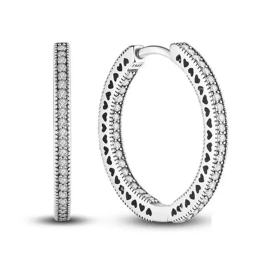 Sterling silver hoop earrings with heart cutouts.