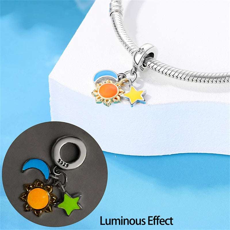 Sun, moon, and star charm in sterling silver with vibrant enamel accents.