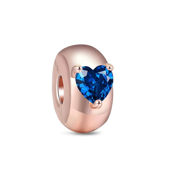 Dazzling Blue Heart Gemstone Charm in Rose Gold - Rose gold charm with a brilliant blue heart-shaped gemstone, symbolizing depth and stability