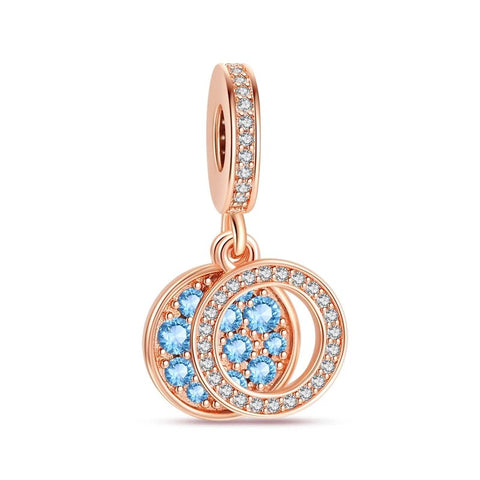 Rose gold charm with double circles, adorned with blue crystals, representing unity and continuity