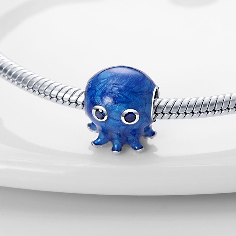 Sterling silver blue octopus charm with sparkling blue gemstone eyes.