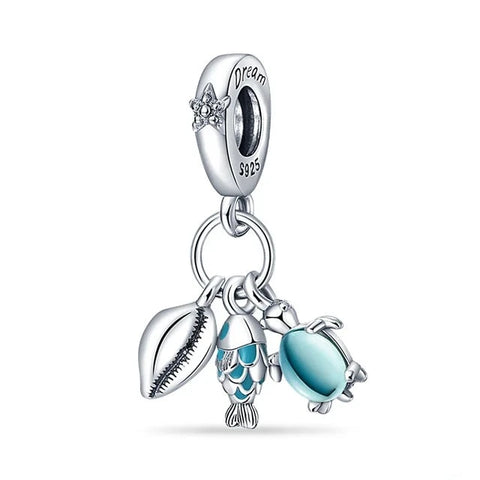 Sterling silver charm with sea shell, fish, and turtle, featuring blue enamel and "Dream" engraving.