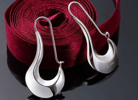 Elegant silver drop earrings with a modern design on a white background shows elegant