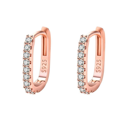 Close-up of rose gold hoop earrings with embedded cubic zirconia stones, isolated on a white background.