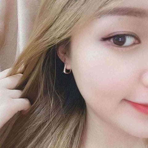 Elegant Sterling Silver Sparkling Hoop Earrings Pave Setting - Close-up of a woman with long blonde hair wearing small rose gold hoop earrings.