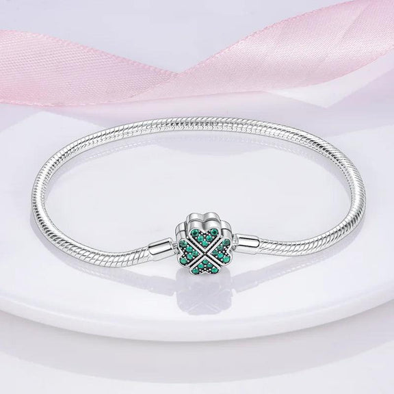 Four Leaf Clover Charm Bracelet - Elegant silver bracelet with a four-leaf clover clasp encrusted with green gemstones, ideal for good fortune.