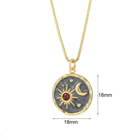 Celestial Sun and Moon Pendant Necklace with Red Crystal Accent - Gold-plated necklace with a round celestial pendant featuband a sun, moon, and red crystal accent.