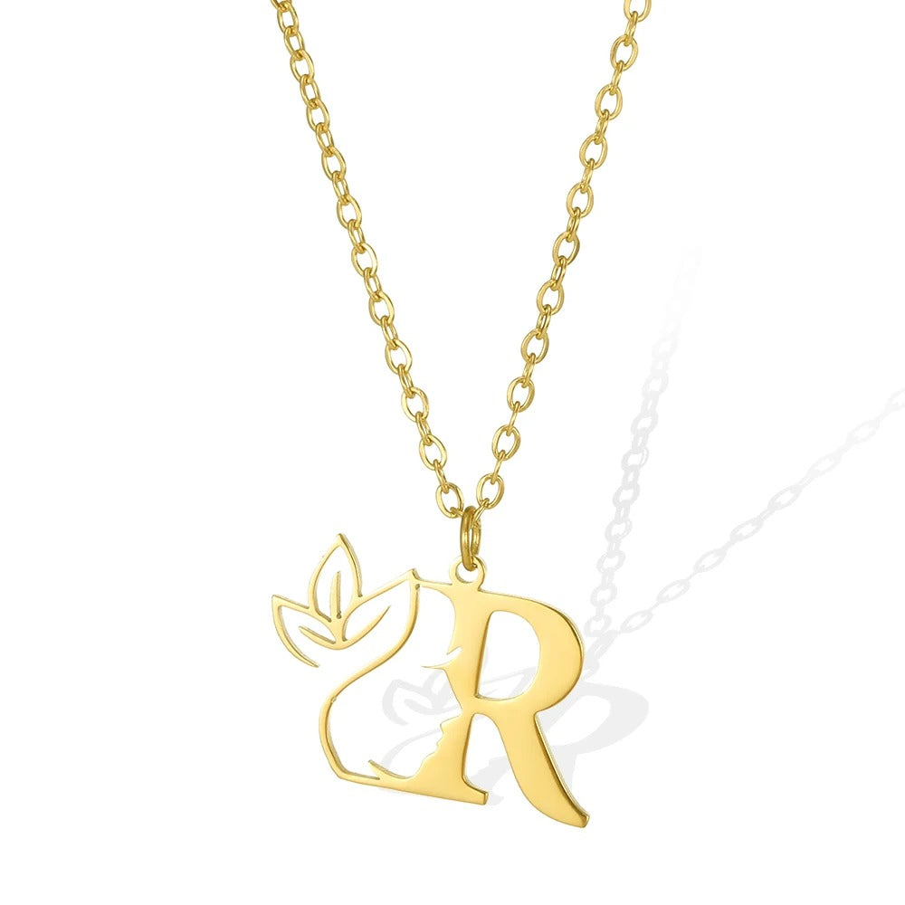 Q: Quaint gold necklace featuring a 'Q' pendant and a detailed leaflet.