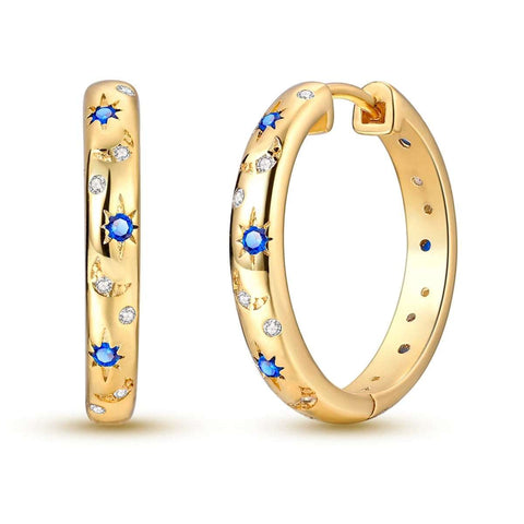 Gold hoop earrings with star and moon designs and blue accents.