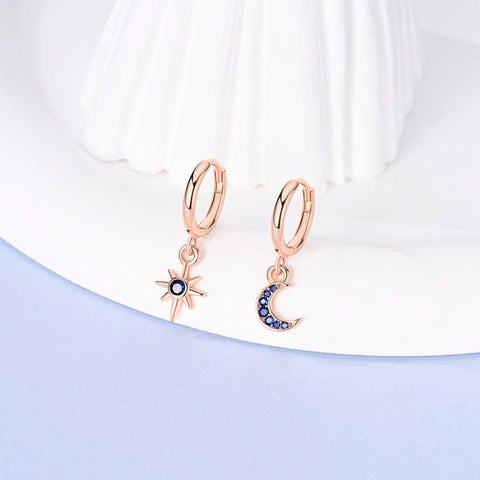 Silver Gold Rose Gold Star Moon Drop Earrings - Sterling silver hoop earrings with star and moon charms displayed on a white surface.