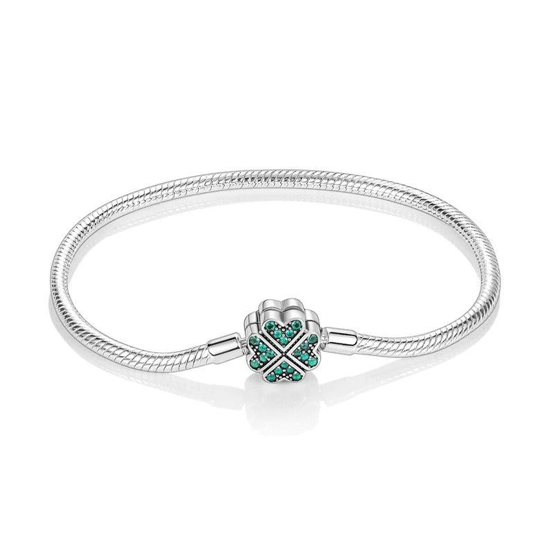 Sterling silver bracelet with a green gemstone four-leaf clover clasp, symbolizing luck.