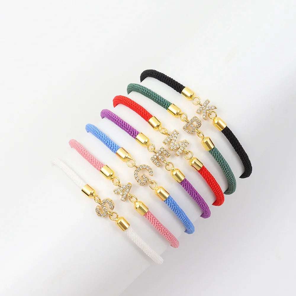 multi color cord bracelet with crystal initial charm and gold-tone accents.