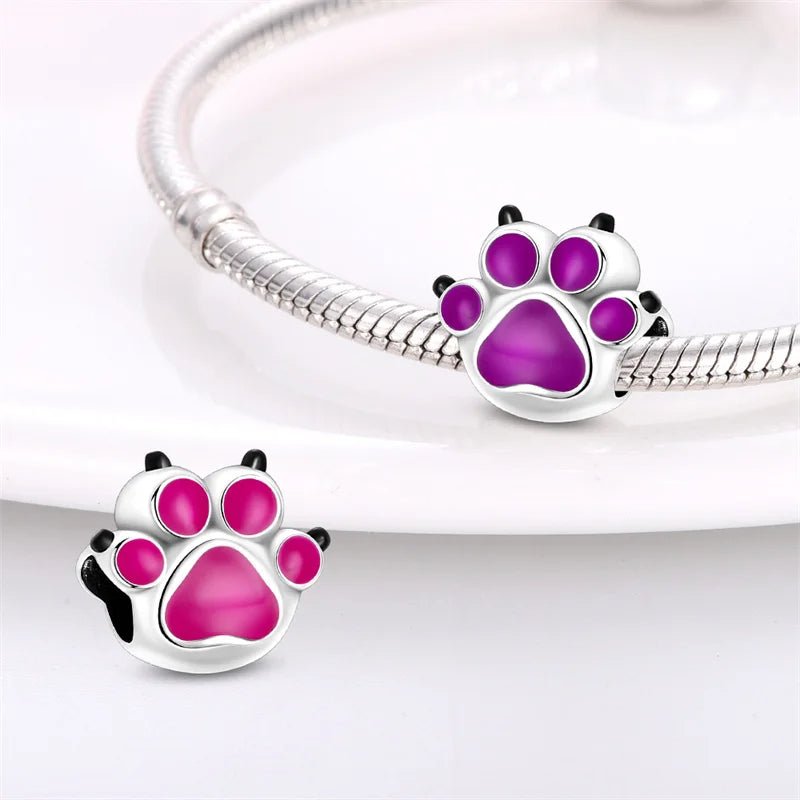 Paw print charm in sterling silver with purple enamel that changes color.