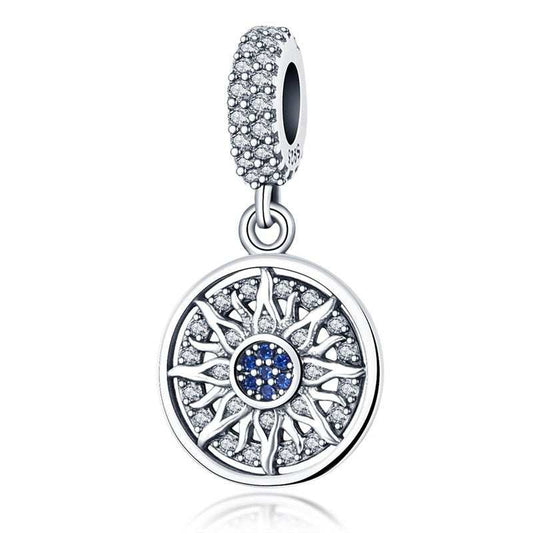 Sterling silver sunburst charm with blue and clear crystals, featuband an intricate design.