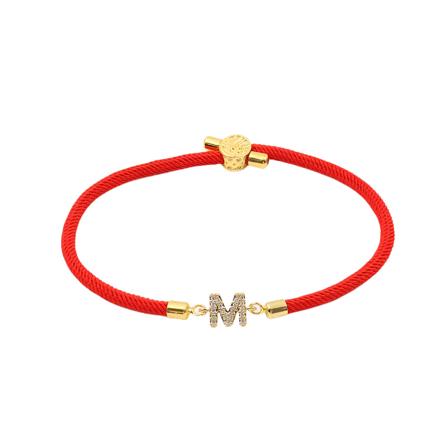 Red cord bracelet with crystal initial charm and gold-tone accents.