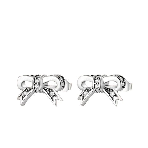 Sterling Silver Bow Knot Stud Earrings Cubic Zirconia Accents - Sterling silver bow knot stud earrings with cubic zirconia accents on a pink background.