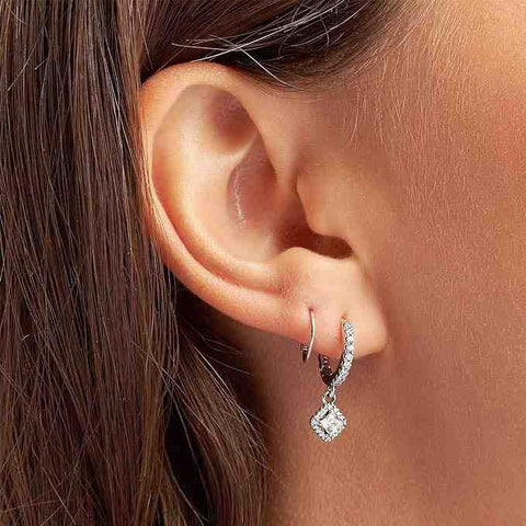 Sterling silver drop earrings with square crystal design, featuring intricate detailing and sparkling crystals in a woman