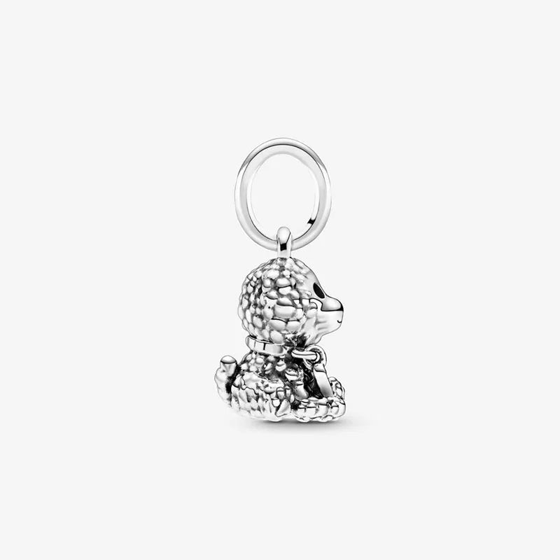 A side profile of a sterling silver poodle charm, highlighting the charming details of the dog’s face and curly fur, with a hanging loop.