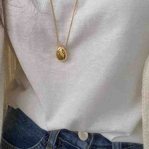 Chic Gold and Silver Teardrop Pendants for Every Occasion - Chic Gold and Silver Teardrop Pendants for Every Occasion - a woman wearing a white sweater and blue jeans