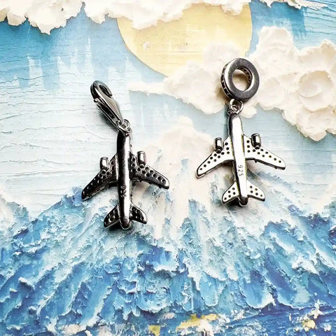 Two silver airplane charms.