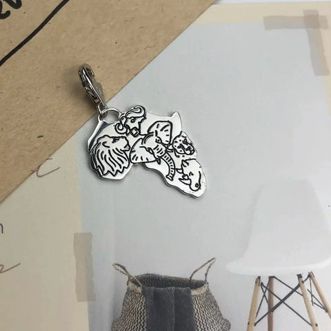Silver Africa-shaped charm with animal cutouts.