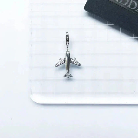 Silver airplane charm.