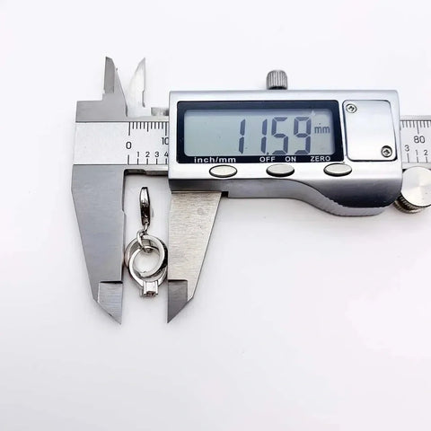 Silver pendant being measured.