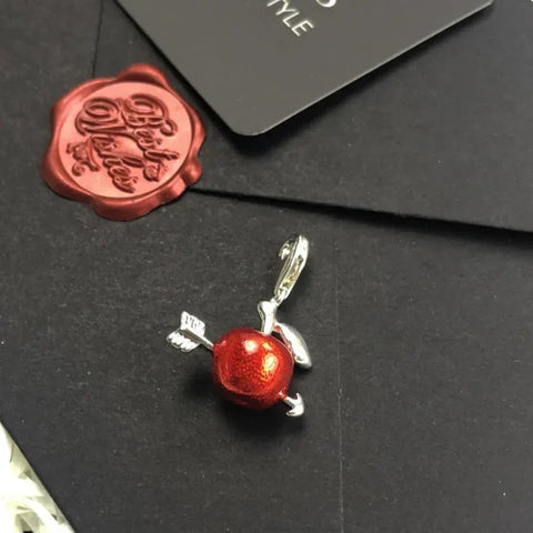 Red apple charm with silver arrow.
