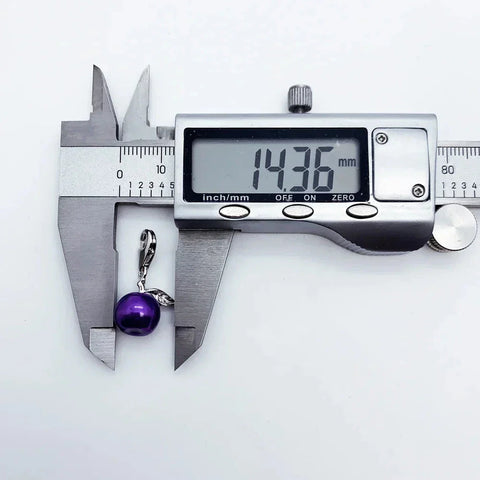 Purple pearl pendant being measured.