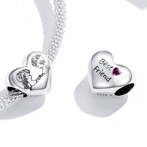 Heart-shaped silver charms with engraved designs on a white background