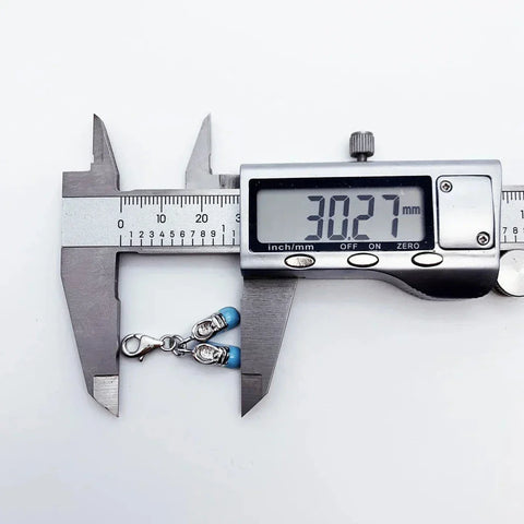 Silver charm bracelet measured by digital calipers.