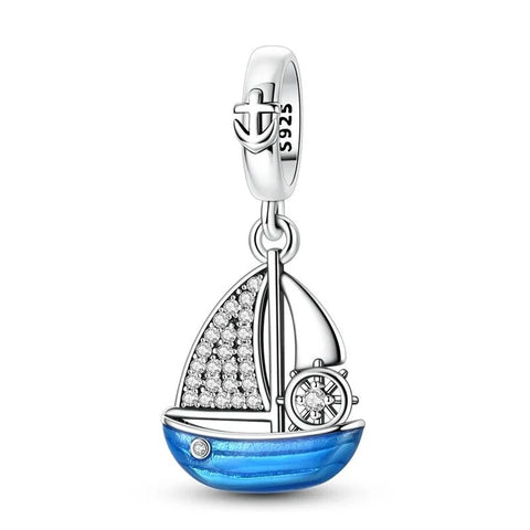 Sterling Silver Blue Enamel Sailboat Dangle Charm - Sterling silver sailboat dangle charm with blue enamel hull, crystal-pavé sail, ship's wheel detail, and anchor bail, on a white background
