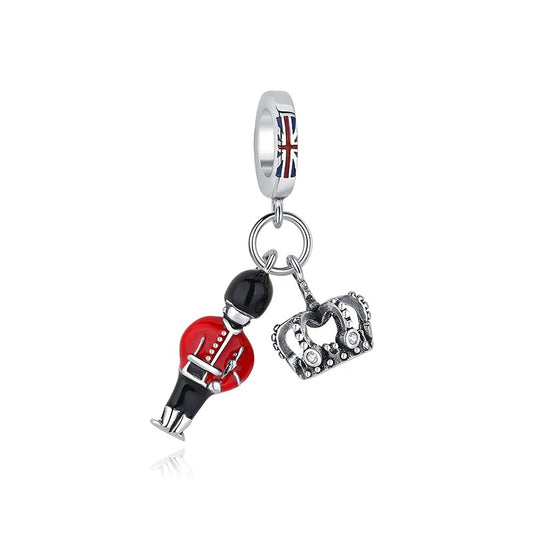 Silver-tone clip-on charm featuring a miniature red-coated British royal guard soldier and an antiqued crown pendant, with a Union Jack enamel bail, on a white background