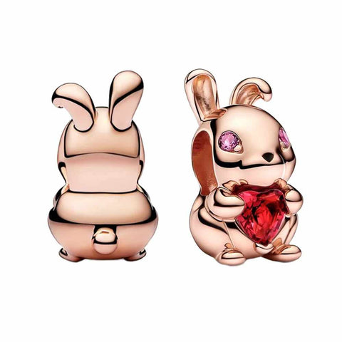 Bunny Charm with Heart-Shaped Crystal in Rose Gold - Bunny Charm in rose gold holding a heart-shaped red crystal, with pink stones for eyes. Perfect for animal lovers and expressing affection.