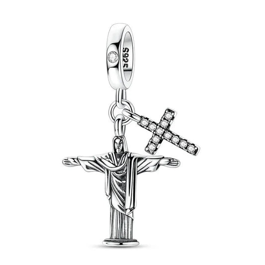 A sterling silver dangle charm featuring the Christ the Redeemer statue with outstretched arms and a separate crystal-studded cross pendant, both hanging from a S925-stamped clip bail