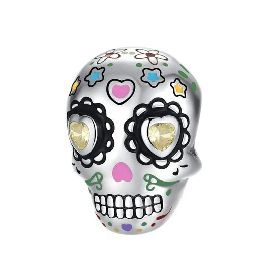 Colorful skull charm with floral decorations and yellow heart eyes, perfect for festive jewelry.