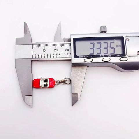 Red car charm being measured.