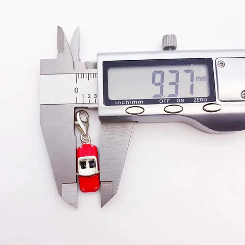 Red and silver charm being measured.