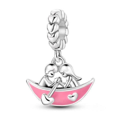 Silver Couple in a Boat Charm - Silver couple in a boat charm with pink enamel accents.
