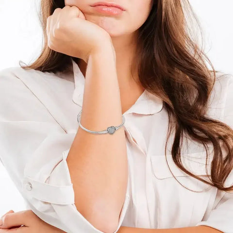 Sterling silver bracelet with a heart charm encrusted with shimmeband stones.