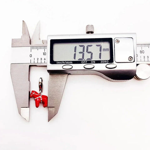 Red Dala horse charm being measured.