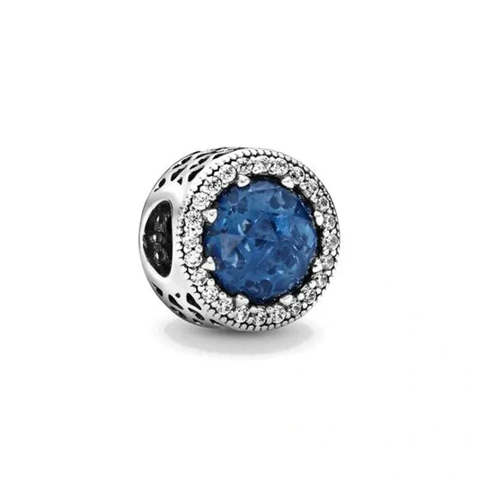 Sterling silver charm with a deep blue gemstone surrounded by a halo of sparkling crystals for an elegant look.
