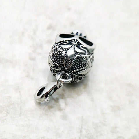 Silver skull pendant with intricate floral designs.