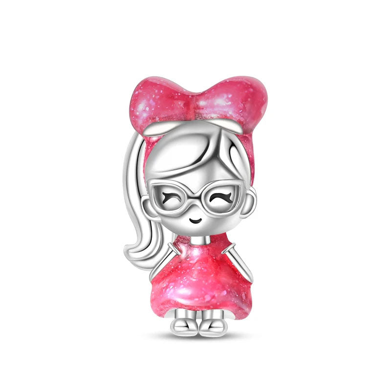 A sterling silver doll charm with a big pink bow, perfect for adding a playful touch to any bracelet or necklace.