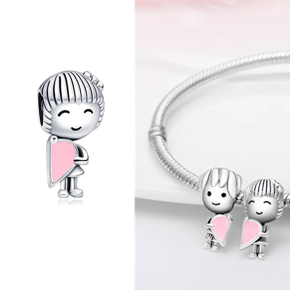 Sterling Silver Girl with Pink Heart Charm for Pandora Bracelets - Sterling silver girl charm holding a pink heart, fits with Pandora bracelets, shown individually and paired with a matching boy charm.